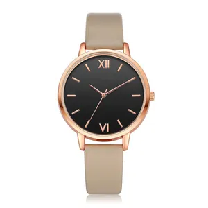 Detail of rose gold minimalist watch with Roman numerals and beige leather strap