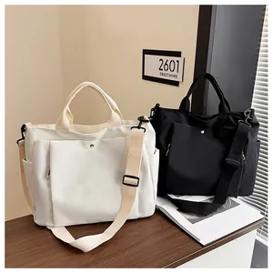 Détail d'un grand sac fourre-tout avec bandoulière réglable et poche à pression métallique