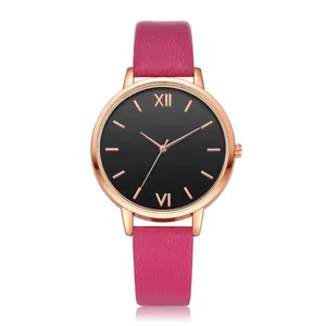 Macro shot of rose gold watch case with black dial and pink textured leather strap