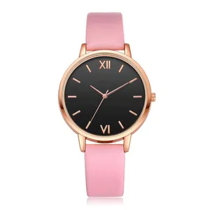 Macro detail of minimalist rose gold watch with black dial and pink leather strap