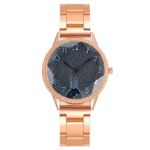 Détail d'une montre en or rose avec lunette en strass et motif lapin sur cadran texturé