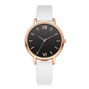 Detail view of the rose gold watch case and black dial with Roman numerals and white strap