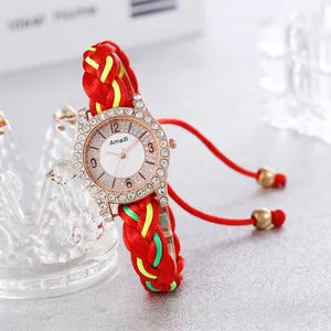 Detail der Amadi Uhr mit goldener Strass-Lünette und buntem geflochtenem Armband