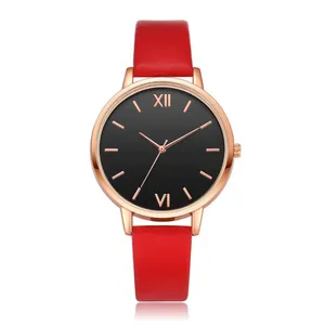 Detail of red leather strap watch with rose gold case and minimalist black dial