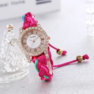 Close-up of bohemian hand-woven strap watch with rhinestone bezel and Roman numerals