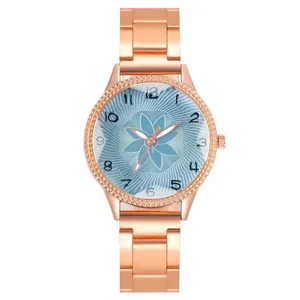 Detail of rose gold watch band with a floral patterned light blue dial and numeric markers