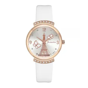 Close-up of rose gold watch case with Eiffel Tower dial and white leather strap