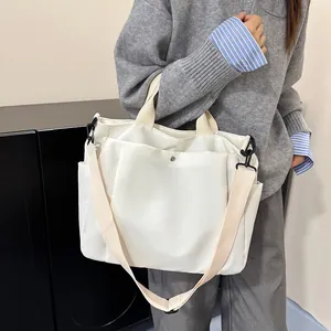 Grand sac cabas blanc minimaliste en toile avec bandoulière et poches latérales