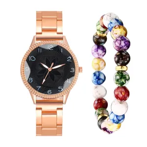 Close-up of rose gold watch with black floral dial and colorful beaded stretch bracelet