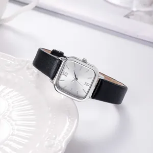 Detailed macro of vintage square silver watch face with black leather strap and Roman numerals