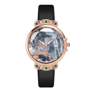 Detail of rose gold watch case with colorful gems and deer motif on dark dial