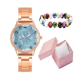 Rose gold quartz watch with blue floral dial, bead bracelet, and pink jewelry gift box