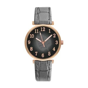 Detail of grey leather strap watch with rose gold case and leaf pattern dial