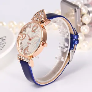 Détail de la montre à quartz or rose avec bracelet en cuir bleu et cœurs diamantés