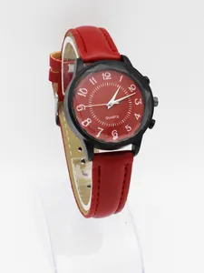 Close-up of a minimalist black case watch with a red dial and matching leather strap