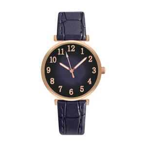 Close-up of navy leather watch strap with rose gold case and Arabic numeral dial