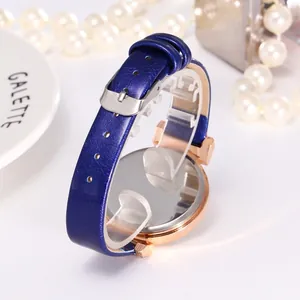 Détails du bracelet en cuir bleu marine et du dos de montre or rose avec perles