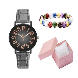 Detailed close-up of ladies' black dial quartz watch with grey leather strap and beaded bracelet