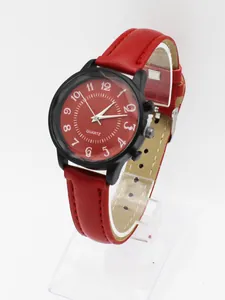 Detail view of red leather strap quartz watch with matte black case and white Arabic numerals