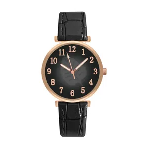 Detail of rose gold watch case with leaf pattern black dial and crocodile embossed leather strap