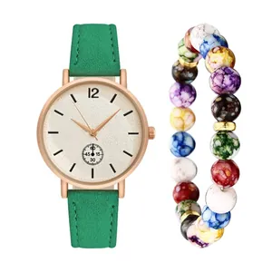 Detail of rose gold quartz watch with green frosted strap and colorful beaded bracelet