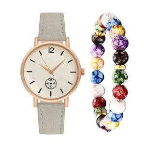 Close-up of rose gold watch with grey frosted strap and colorful beaded charm bracelet