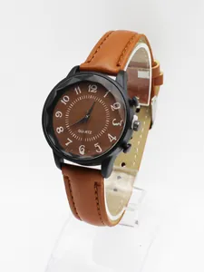 Macro side view of minimalist watch with brown leather strap and matte black case