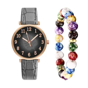 Detail of rose gold watch with leaf pattern dial and colorful beaded charm bracelet