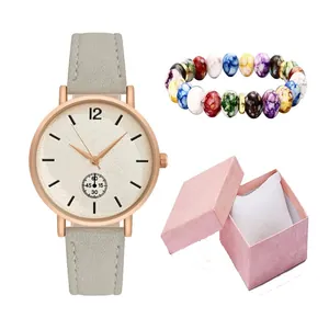 Detail of quartz watch with matte strap and beaded bracelet in a pink gift box