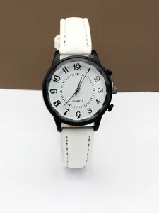 Macro shot of minimalist quartz watch with white dial, black numerals, and wavy texture detail