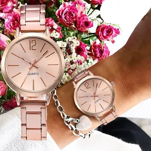 Détail de la montre à quartz or rose et bracelet cœur sur fond de roses roses