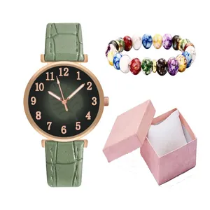 Detail of leather strap watch and beaded bracelet in a textured pink gift box