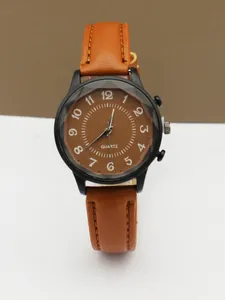 Detail of minimalist watch featuring a brown textured dial and geometric cut glass edge