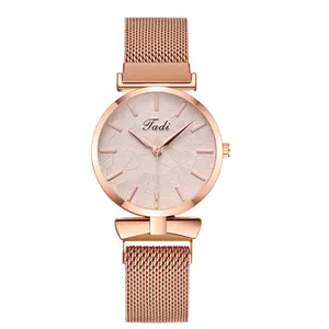 Detail of rose gold ladies watch featuring a textured leaf dial and milanese mesh strap