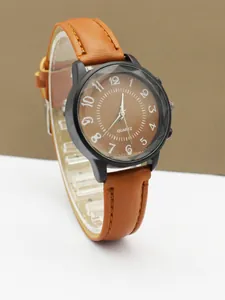 Close-up of minimalist black quartz watch with brown dial and white Arabic numerals