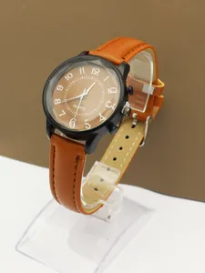 Detail view of quartz watch with brown leather strap and black round case on stand