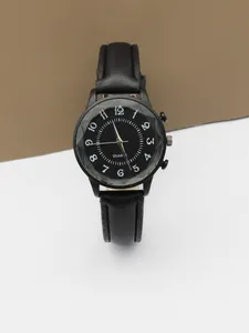 Detail of minimalist black quartz watch featuring faceted crystal glass and numeric dial