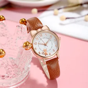 Close-up of a women's quartz watch with cat ear case and brown leather strap on pink background