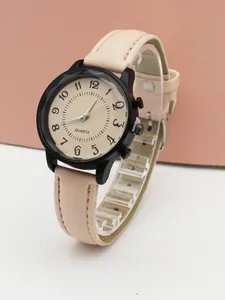 Macro shot of minimalist women's quartz watch with pink leather strap and black alloy case