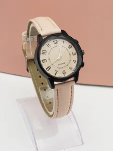 Detail view of pink leather strap and black quartz watch with artistic numerals