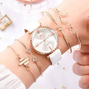 Détail de la montre blanche RINNADY en cuir PU et de quatre bracelets en or rose au poignet