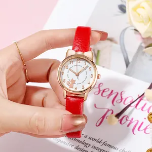 Close-up of rose gold cat-ear watch with red leather strap and cute cat dial on hand