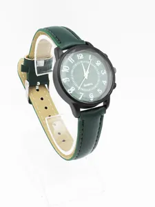 Minimalist quartz watch detail featuring dark green dial with Arabic numerals and black matte case