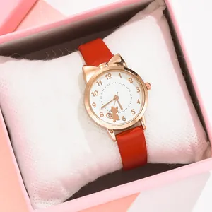 Dettaglio dell'orologio con orecchie da gatto oro rosa e cinturino in pelle rossa