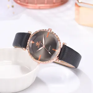 Détail de montre quartz or rose avec cadran taupe et bracelet en cuir noir pour femme
