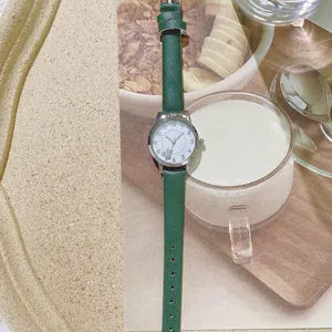 Dettaglio del cinturino in pelle verde scuro e cassa con orecchie di gatto su orologio