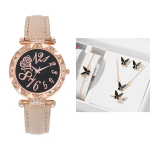Details einer roségoldenen Diamant-Uhr und Schmetterlings-Schmuckset in weißer Box