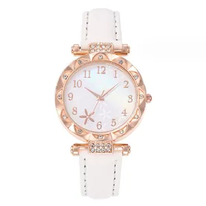 Detail of rose gold watch with rhinestone bezel and white floral pattern dial