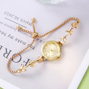 Détail de la montre bracelet dorée avec maillons feuilles en cristal et fermoir bolo réglable