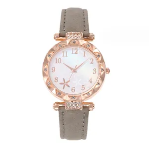 Detail of rose gold case with crystal bezel and floral pattern dial on gray leather strap
